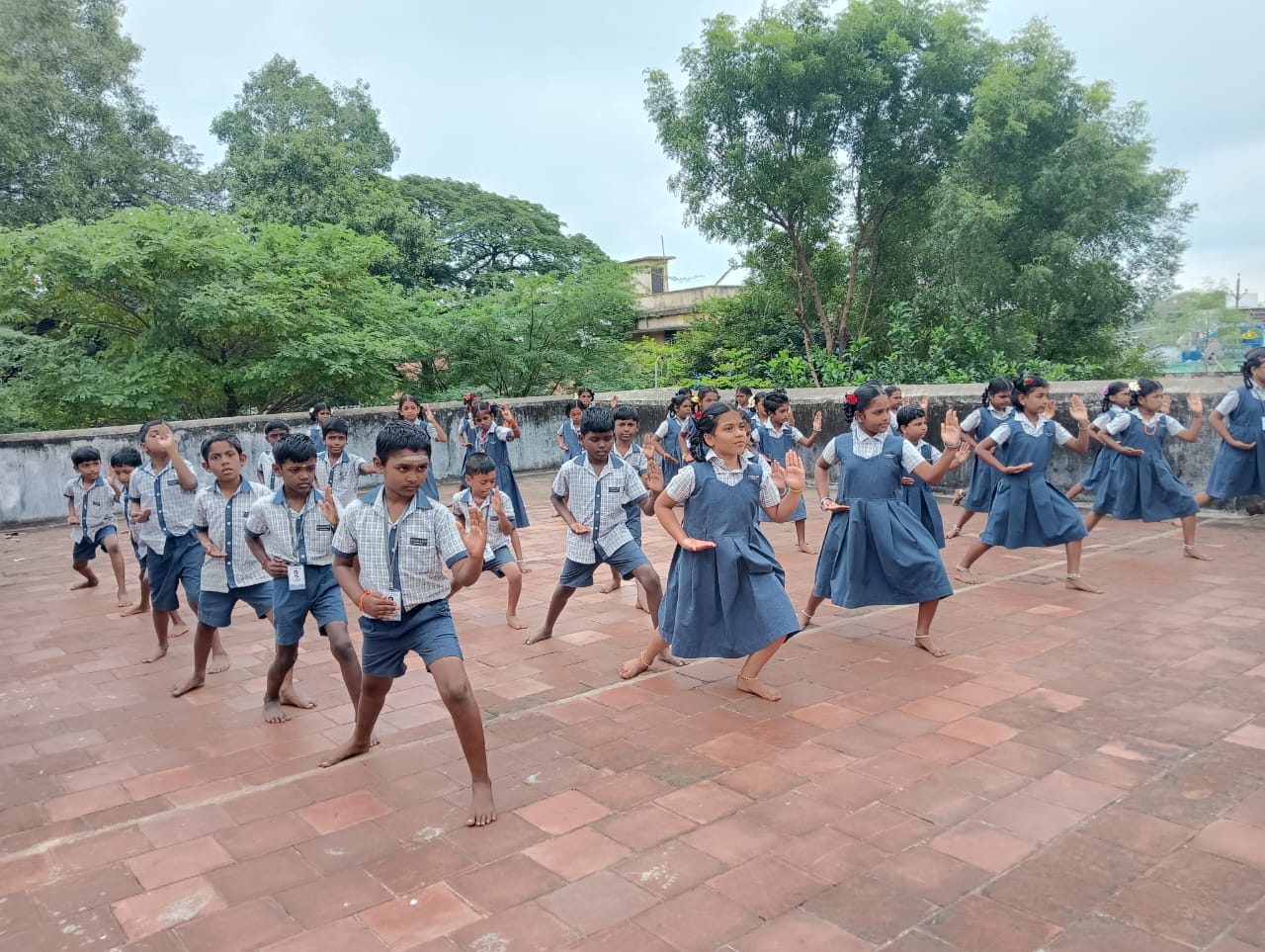 Children practising silambam in unison on the school terrace